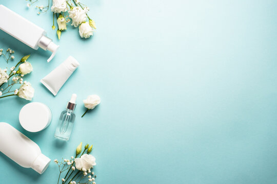 Natural cosmetic products. Cream, serum, tonic with green leaves and flowers. Skin care concept. Flat lay image with copy space.