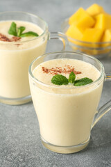 Lassi mango. Traditional Indian drink, gray background. Summer refreshing smoothie. Side view, selective focus.