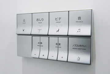 Electronic commands of high-tech Japanese toilets on the wall.
