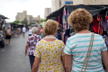 Two elderly women at a street market