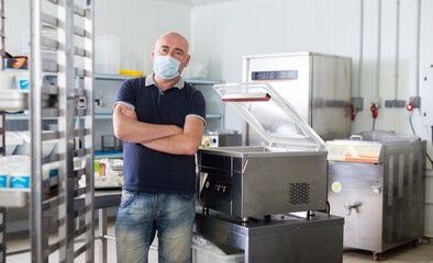 Man in mask on the background of the equipment of the dairy shop