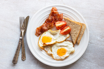 Breakfast food fried egg bacon bread and coffee on wood table.