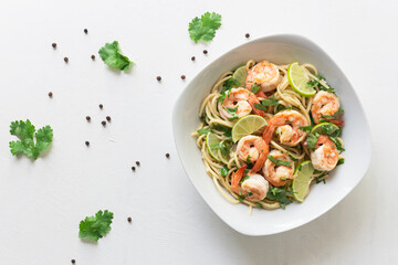 Shrimp pasta lemon coriander in white bowl on white background Italian food.