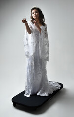 Full length portrait of beautiful woman wearing  fantasy costume, white bridal gown.  standing...