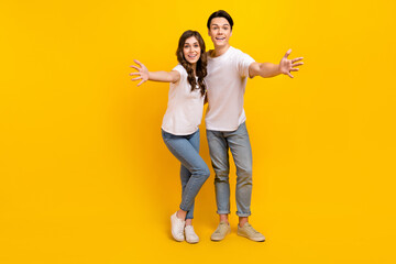 Fototapeta premium Full length photo of cute impressed husband wife dressed white t-shirts open arms empty space isolated yellow color background
