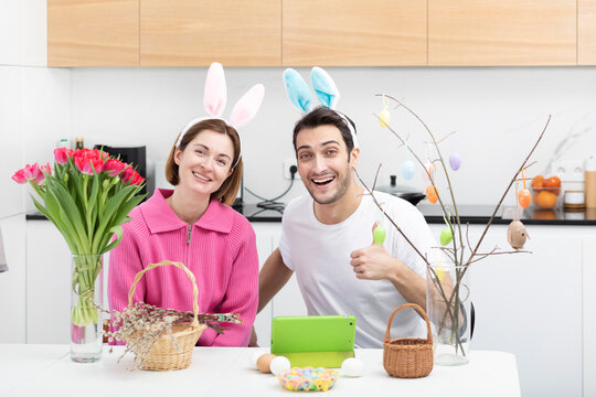 Funny couple wearing bunny ears headband celebrating Easter together at home