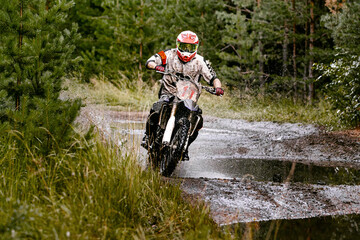 motocross enduro race athlete motorcyclist rides on a forest trail