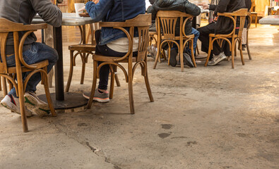 Unrecognizable people sit in a café or restaurant outside, drink coffee and talk, Low section of people at a street café , copy space