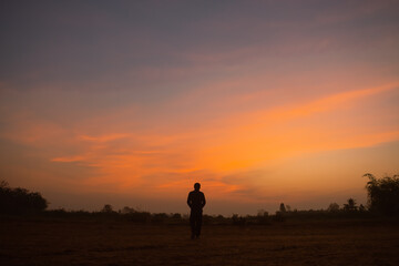 Obraz na płótnie Canvas Silhouette man standing in the sunset.
