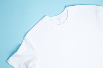 Basic folded white t-shirt blue background. Mock up for branding t-shirt. Copy space