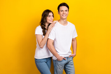 Photo portrait of young cheerful satisfied husband with wife wear white t-shirt touch shoulder look candid isolated on yellow color background