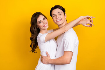 Photo of charming positive husband wife dressed white t-shirts embracing empty space isolated yellow color background