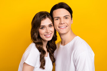 Closeup portrait of positive smiling two people faces together touch cheeks white teeth stomatology advertisement isolated on yellow color background