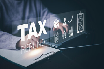 Businessman using a pen to write a notebook with TAX REFUND and refund tax of duty taxation...
