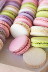 Macaroons in box. French macaroon cake. Sweet macarons or macaroons, flavored cookies are in the paper box. Colorful pink blue yellow green macaron. Sweet macaroons macarons.