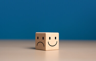 Emotional state and mental health concept, Smile face on bright side and sad face on dark side of wooden block cube for positive mindset selection. - obrazy, fototapety, plakaty