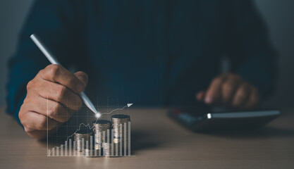 Businessman drawing an increasing graph with coin stacking for increased financial interest rate. Inspiration for business investment, and growth from dividend concept.