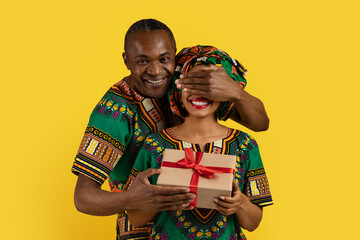 Loving black man make surprise for wife, wearing african outfits