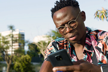 use technology as a tool to organize your business, young man using his phone outdoors