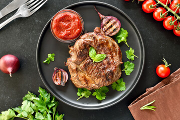 Juicy grilled beef steak and tomato sauce on plate
