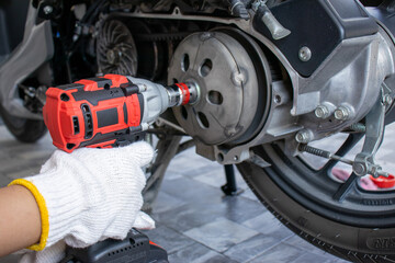 A mechanic is inspecting and repairing a motorcycle in a garage. and fix the engine according to industry standards