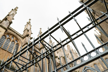 Vertical aspect of a protective, metal spiked gate seen at the entrance to an English cathedral in East Anglia.