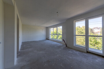 New empty room under construction. Plaster walls. New home. Concrete walls. Interior renovation.