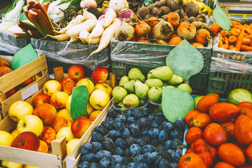Fresh organic produce on sale at local farmers market. Close up of various colorful seasonal vegetables and fruits at city market. Autumn harvest and healthy organic food concept.