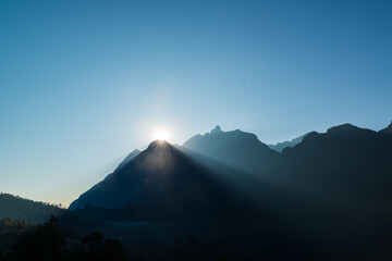 The morning sun shines from the back of Doi Luang Chiang Dao mountain when seen from Ban Na Lao Mai, Chiang Dao, Chiang Mai, Thailand.