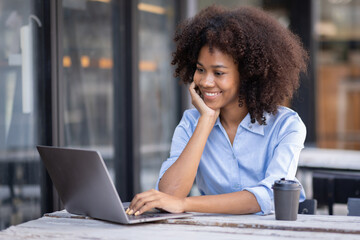 Young happy professional business woman worker employee sitting at desk working on laptop in...