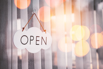 Open sign hanging front of cafe with colorful bokeh light abstract background. Business service and food concept.