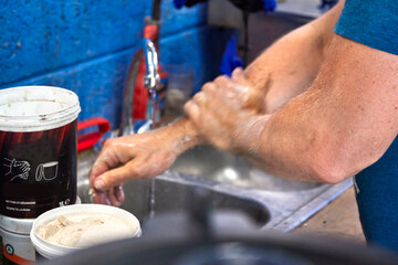 A mechanic washing his hands and arms after work with a very efficient product