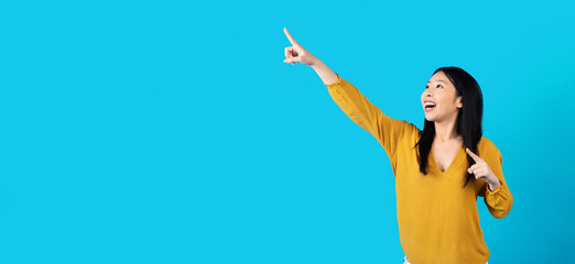 Excited korean woman pointing at copy space for advertisement