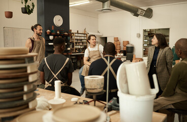 Diverse ceramics studio team talking during a meeting together