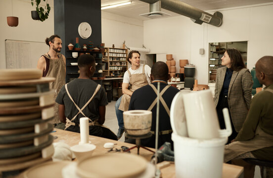 Diverse ceramics studio team talking during a meeting together