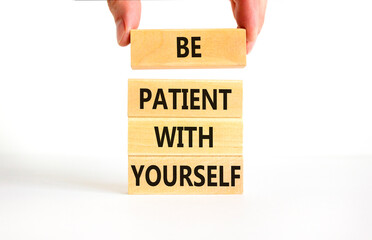 Patient with yourself symbol. Concept words Be patient with yourself on wooden blocks. Beautiful white table white background. Businessman hand. Business patient with yourself concept. Copy space.