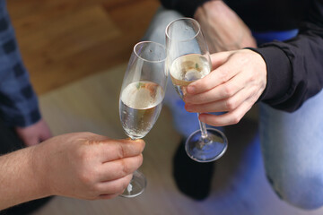 two people clinking glasses with champagne