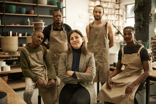 Smiling manager and her diverse team working in a ceramics studio