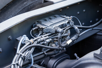 Close-up of a truck pneumatic component with lots of hoses and wires on a frame