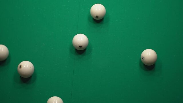 a man tries to correctly break a pyramid of white balls in billiards. slow-motion video. close-up. High-quality video recording in Full HD format.