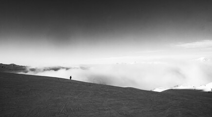 Lone figure lies above the fog in the mountains