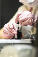 The manicurist cleans and removes the cuticle from the nail plate. Manicure process. Cut manicure technique. Special equipment for trimmed manicure.