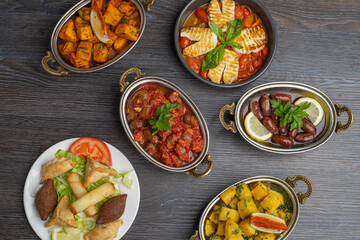 Set of Lebanese mezze of Spicy potatoes, potato cubes, cheese rolls, kibbeh, spinach, sausage, makanek, halloumi cheese
