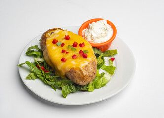 Baked potatoes with cheese and garnish and dip isolated on white background 