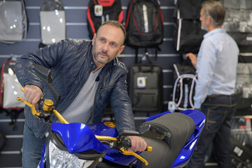 Fototapeta na wymiar handsome mature man at the motorbike store