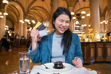 smiling asian female hand hold credit card sit relax casual at restaurant ,asian female hand hold credit card cashless lifestyle ideas concept,Asia woman show plastic credit card in restaurant