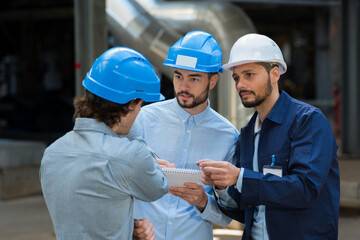 three engineer talking about work at construction site