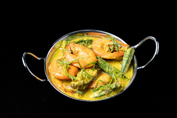 Udang Masak Lemak or Prawn coconut curry on white bowl, soft focus