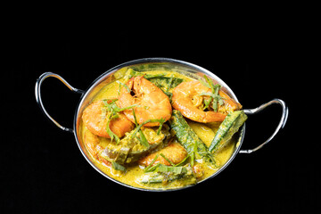 Udang Masak Lemak or Prawn coconut curry on white bowl, soft focus