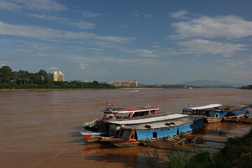 Fototapeta premium Mekong River tour boats, with Laos in the background in Ban Sop Ruak in the Golden Triangle, Chiang Rai Province, Thailand 